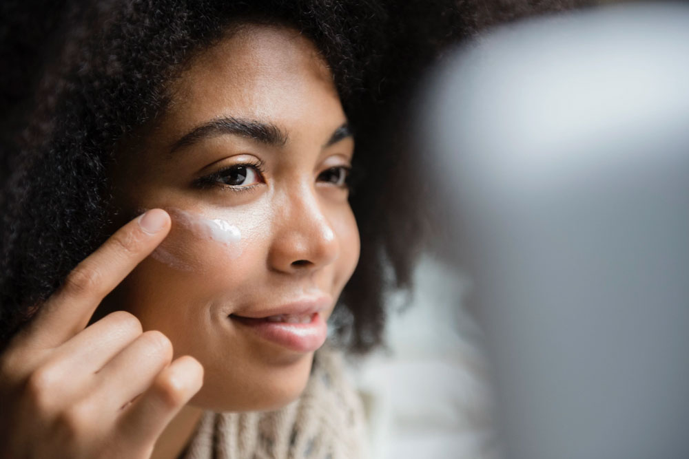 woman putting lotion on face