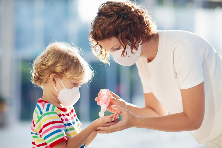 woman helps kid with mask