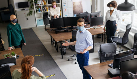 businessman addresses employees in masks