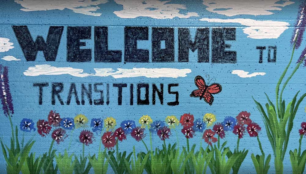 welcome to transitions mural with flowers and butterflies