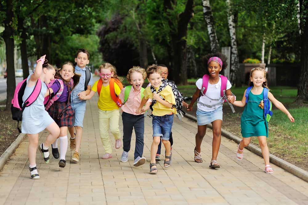 Group of children holding hands with backpacks